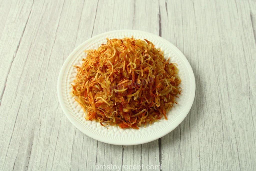 Щедро покройте салат хрустящей картофельной соломкой, создавая эффект "муравейника".
