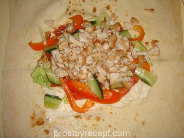 Щедро уложите на мягкий лаваш ароматное куриное мясо, а затем