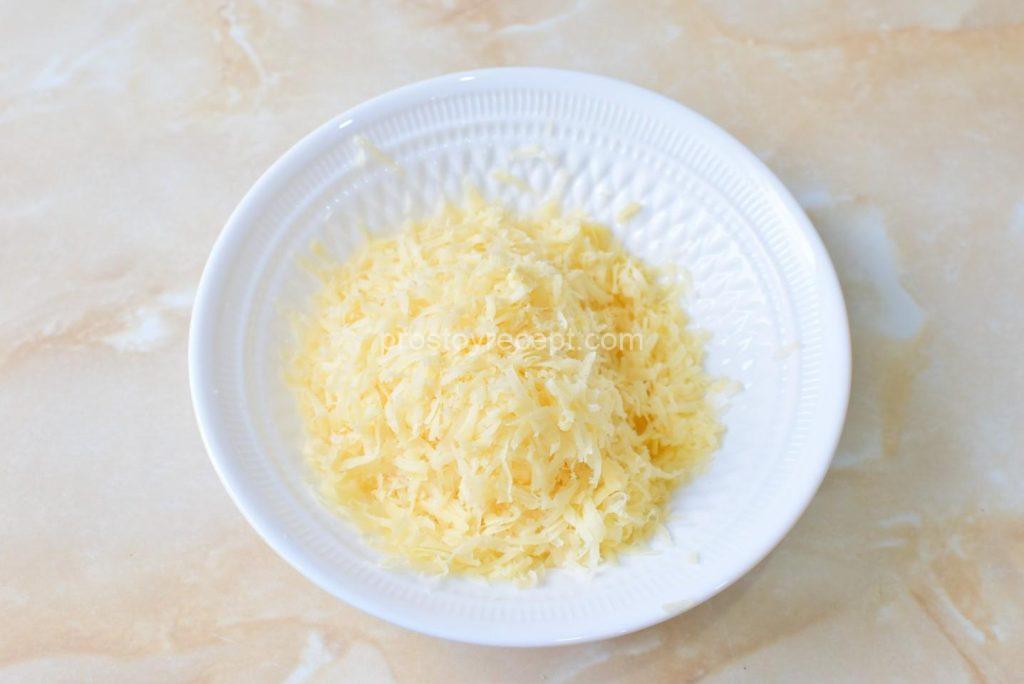 Натрите сыр на мелкой тёрке, готовя ароматную сырную начинку.