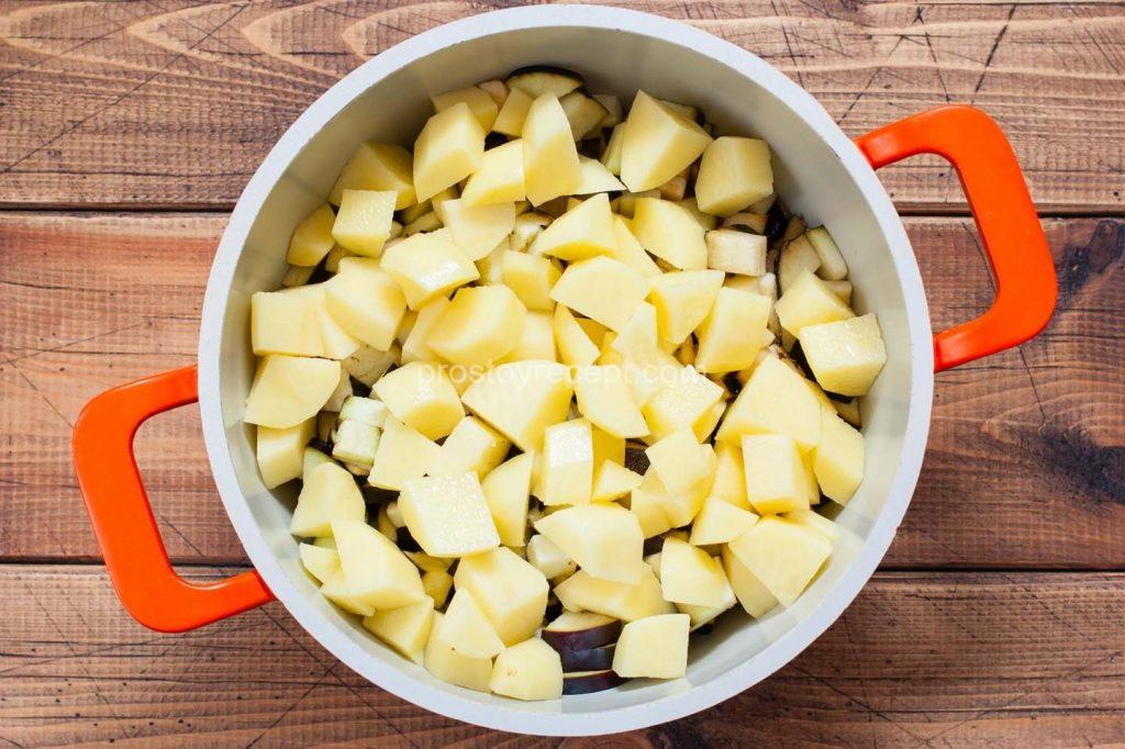 Очищенный картофель нарежьте кубиком и аккуратно распределите поверх баклажан, слегка