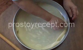 Раскатанное тесто для пахлавы в форме, края расправлены.