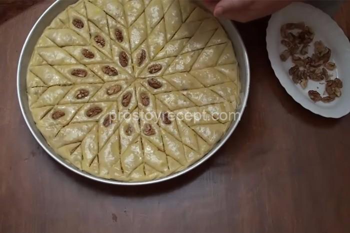 Аккуратно поместите по одному грецкому ореху на каждый ромб теста,