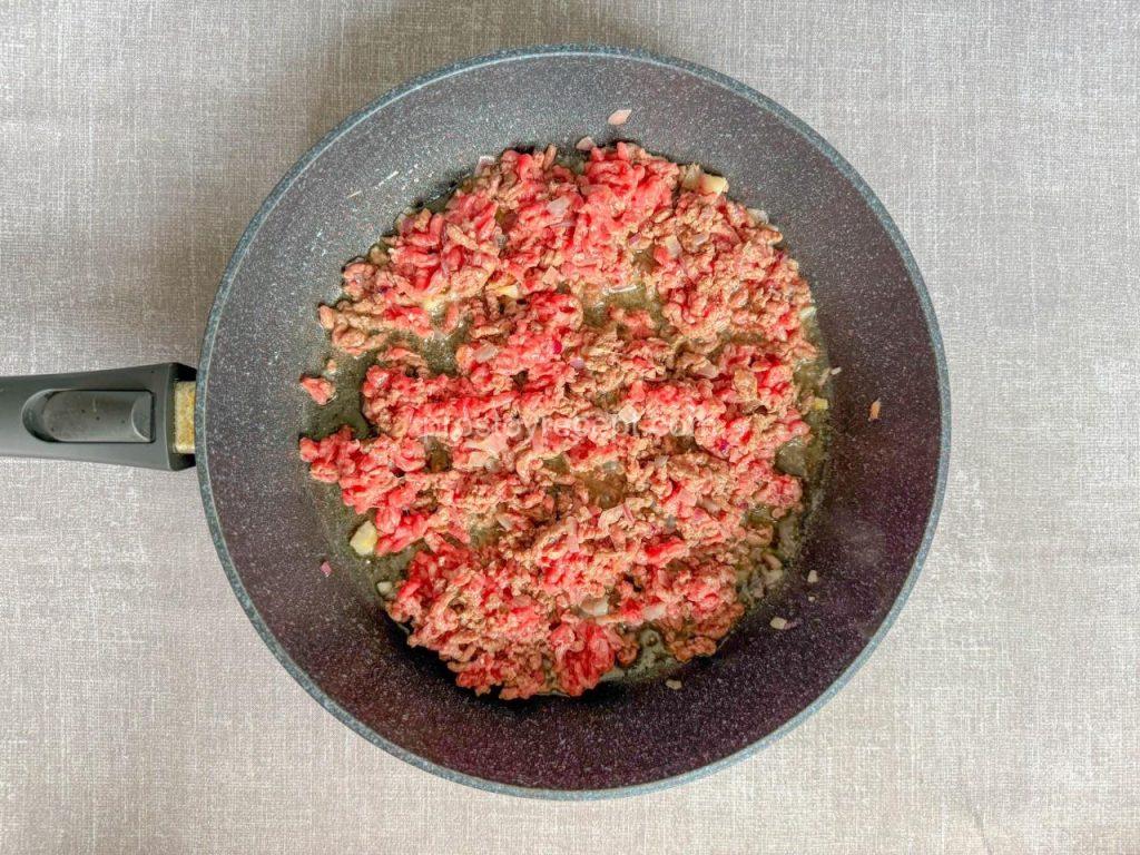 Аккуратно, но энергично, разминайте фарш в сковороде, разбивая все комочки