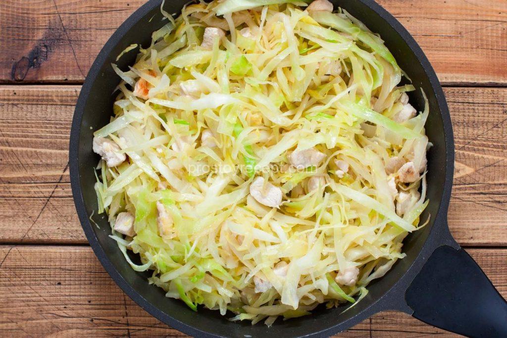 Нашинкованную капусту добавьте в сковороду к куриному филе, перемешайте, накройте