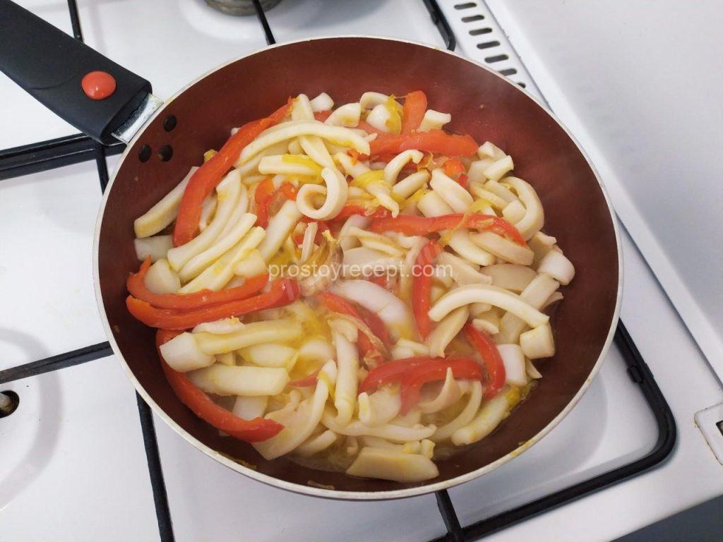 Выложите кальмаров в сковороду к овощам и обжаривайте на сковороде