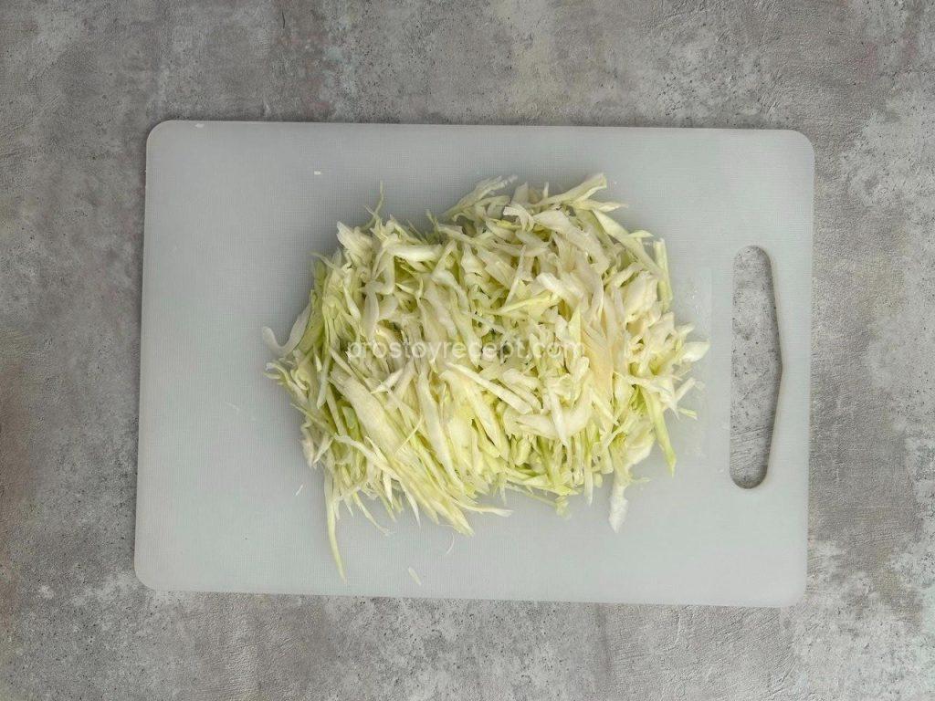 Нашинкуйте тонкой соломкой капусту и сладкий красный перец.