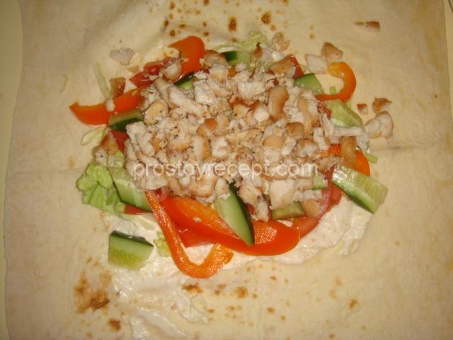 Выкладываем на лаваш куриное мясо и подготовленные овощи.
