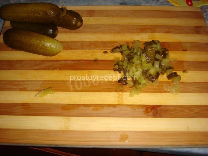 У соленых огурцов обрезаем кончики и нарезаем кубиками.
