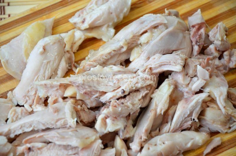 Извлеките мясо из готового бульона, пока оно теплое, отделите от